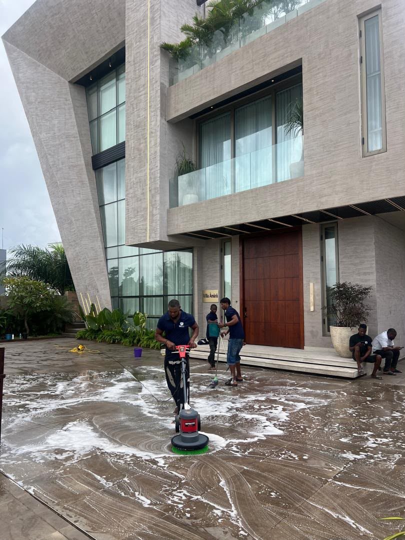 Team scrubbing a large outdoor terrace with a floor scrubber