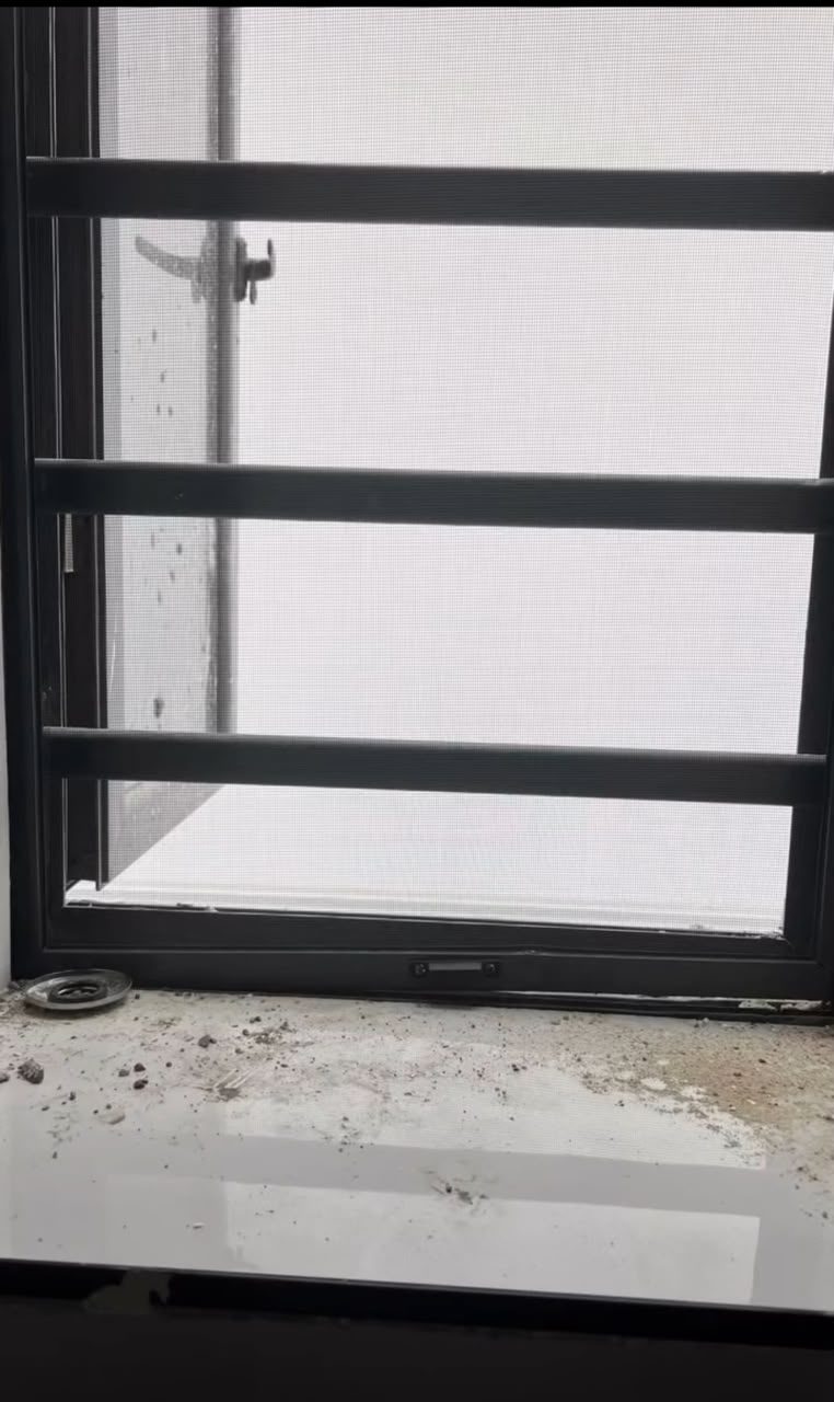 Window sill covered in dust and construction debris